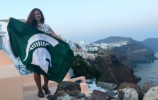 Student standing with Spartan flag in Greece